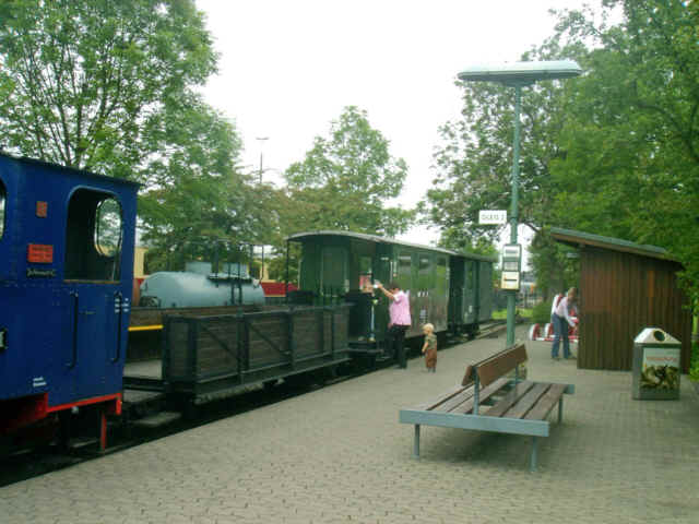 Miniatur Bahnhof mit offenem Schmalspurwagen.